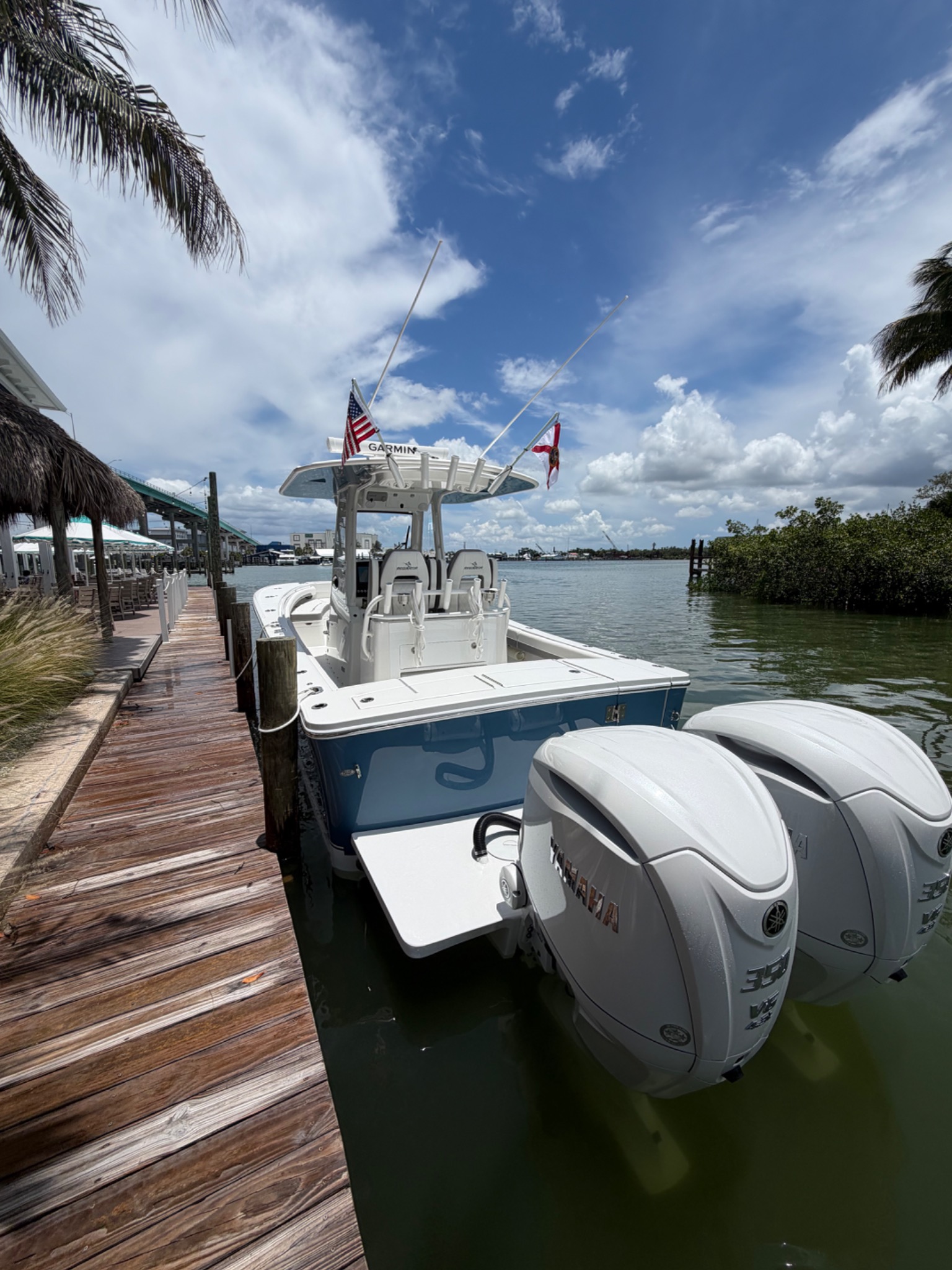 Blue and white center console boat with twin Yamaha outboard engines
